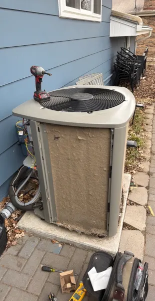 Outdoor condenser coated in seed fluff, before cleaning
